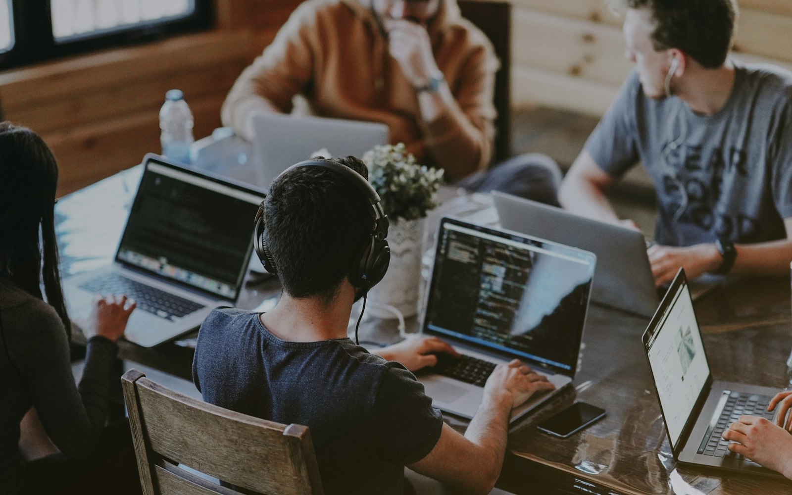 A diverse digital team planning lead-generation campaigns on laptops